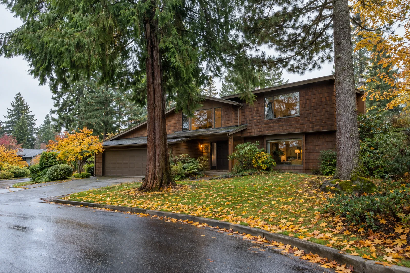 Cedar-shingled Northwest contemporary home under tall evergreens on a quiet Cedar Mill, Oregon street in autumn